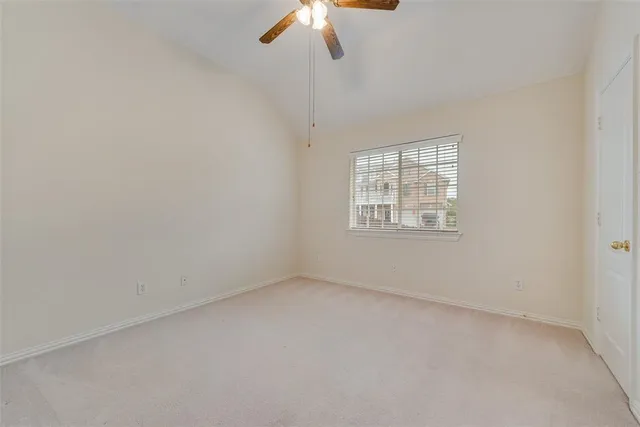 an empty room with a window and a fan