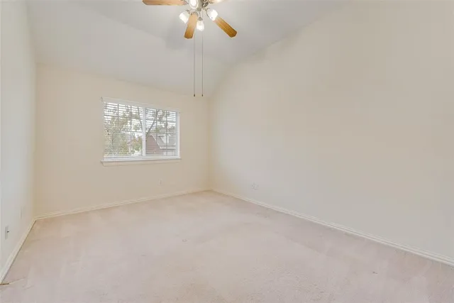 en empty room with windows and chandelier fan