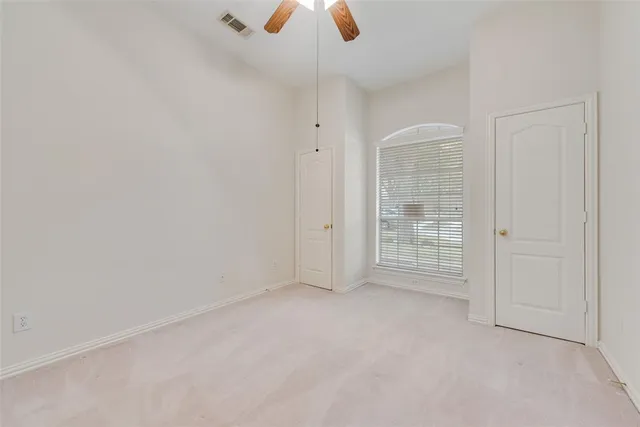 an empty room with chandelier fan