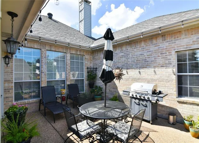 a backyard of a house with table and chairs