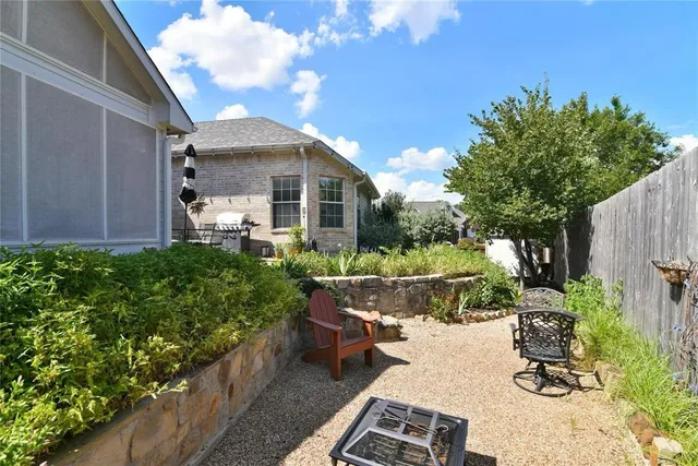 a view of a chair and table in backyard of the house