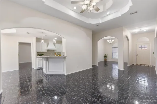 a view of an empty room and kitchen view