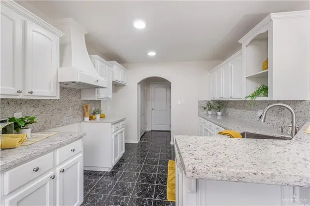 a kitchen with stainless steel appliances granite countertop a sink stove refrigerator and cabinets