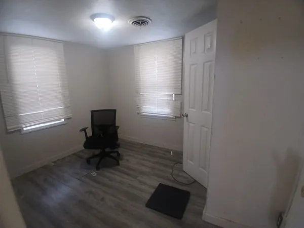a view of workspace with wooden floor lounge chair and windows