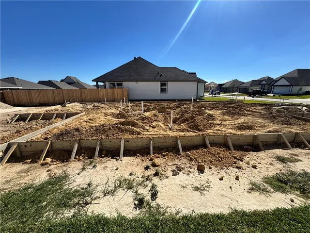 a view of a lake with lawn chairs under an umbrella