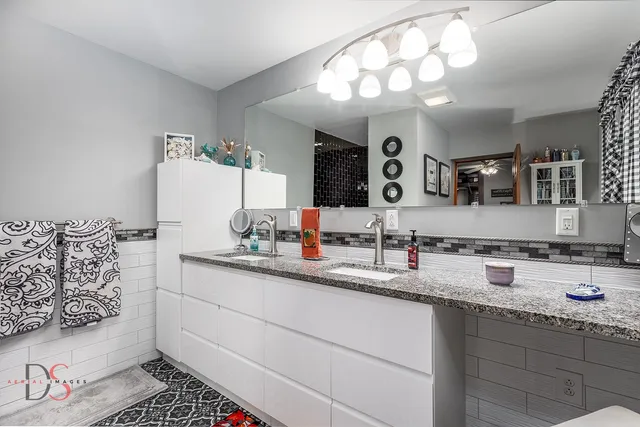 a bathroom with a sink double vanity granite and a mirror