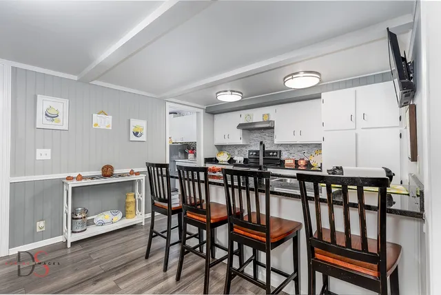 a kitchen with a table chairs sink and cabinets