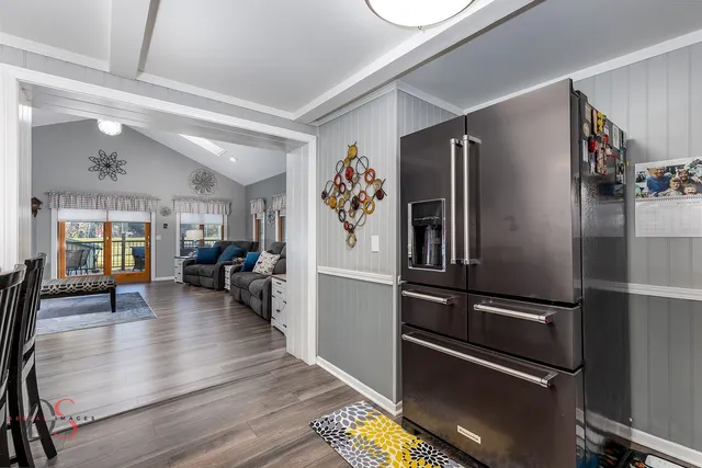 a kitchen with stainless steel appliances a refrigerator and wooden floor