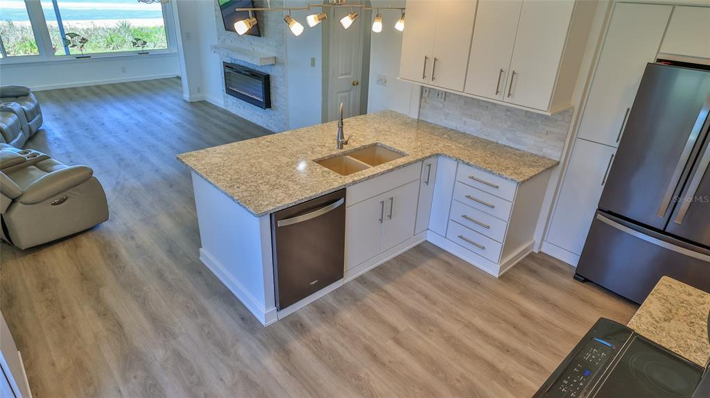 8 Ocean Dunes Drive Ormond Beach, FL 32176 - Photo 22 of 55 a kitchen with stainless steel appliances granite countertop a sink dishwasher stove and wooden floor