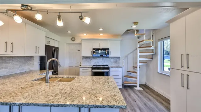 a kitchen with granite countertop a stove and cabinets