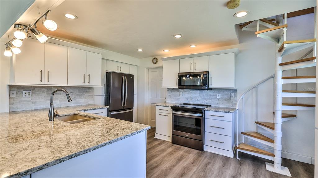 8 Ocean Dunes Drive Ormond Beach, FL 32176 - Photo 10 of 55 a kitchen with granite countertop a stove and cabinets