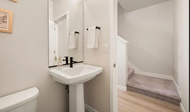 a bathroom with a sink a toilet and mirror