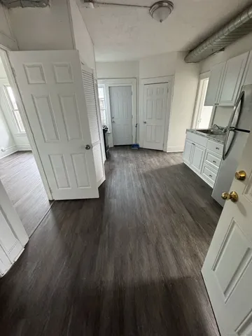 a view of empty room with wooden floor