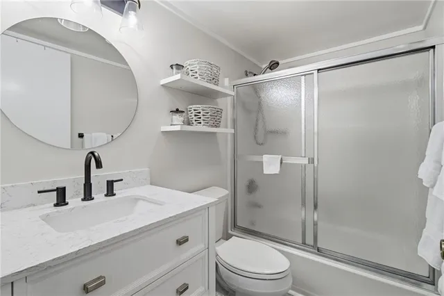 a bathroom with a sink a mirror a toilet and shower