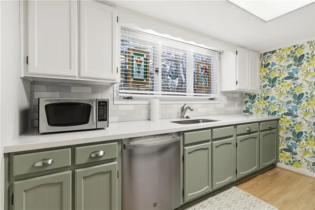 a kitchen with stainless steel appliances granite countertop a sink and a microwave