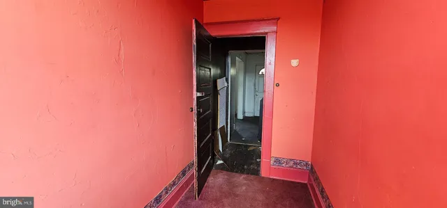 a view of a room with a hallway and wooden shelves