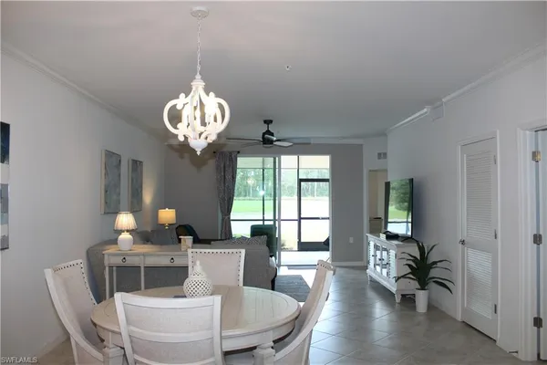 a dining room with furniture a chandelier and window