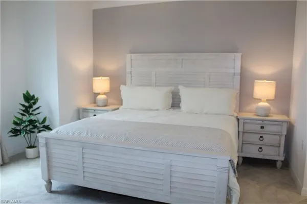 a bedroom with a bed and a potted plant