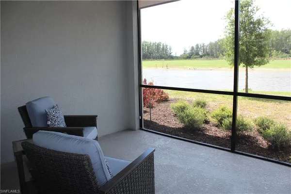 a room with a bed and large windows