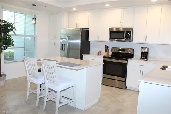 a kitchen with stainless steel appliances a stove microwave and refrigerator