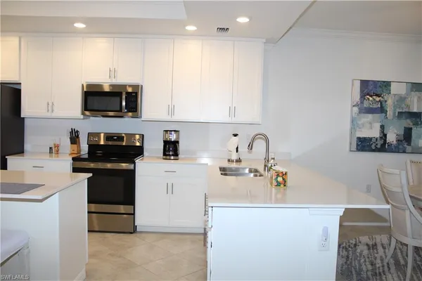a kitchen with stainless steel appliances granite countertop a sink a stove top oven a counter space and cabinets