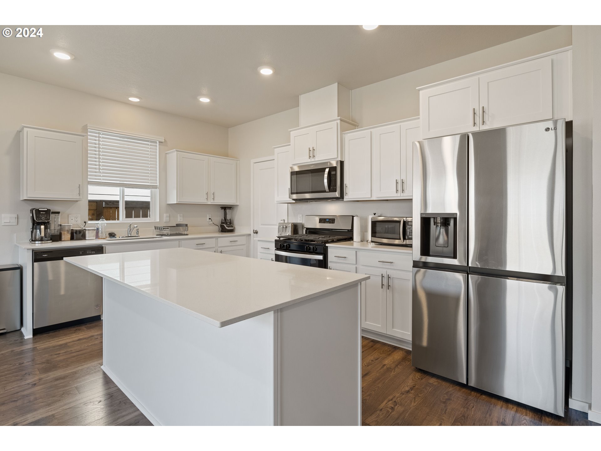 2898 V Street Springfield, OR 97477 - Photo 11 of 47 a kitchen with kitchen island a white cabinets and refrigerator