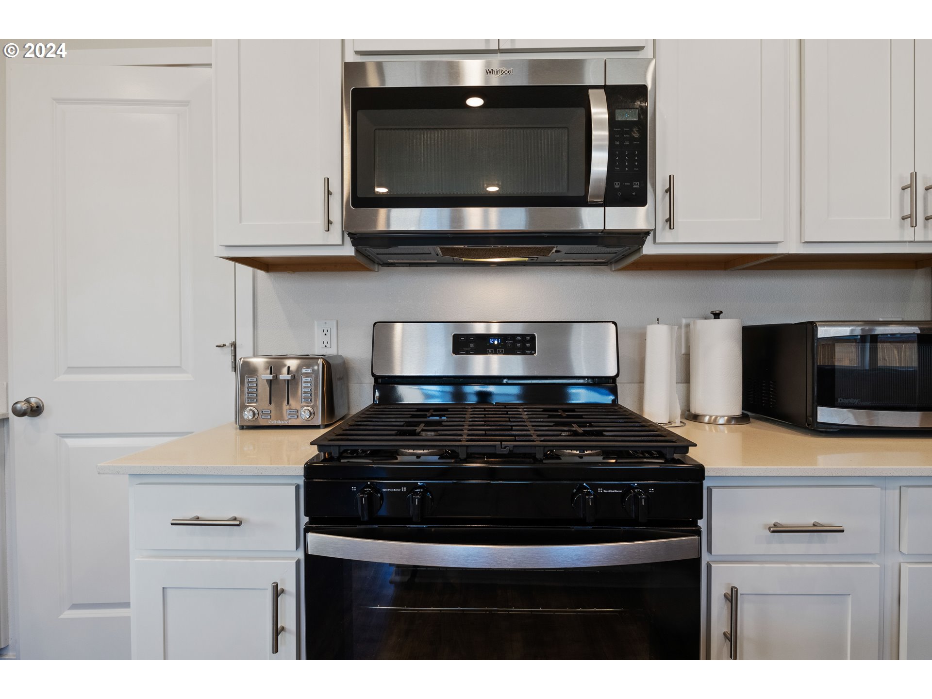 2898 V Street Springfield, OR 97477 - Photo 17 of 47 a kitchen with stainless steel appliances granite countertop white cabinets and black stove top oven with granite countertops