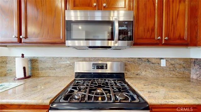 a kitchen with granite countertop a stove and cabinets