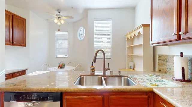 a kitchen with granite countertop a sink a counter top space and cabinets