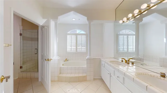a spacious bathroom with a tub sink and mirror