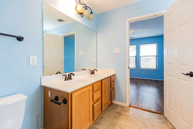 a bathroom with a sink a toilet and mirror