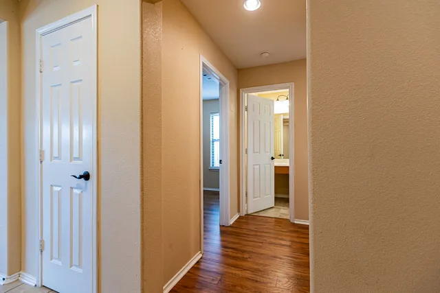 a view of a hallway with wooden floor
