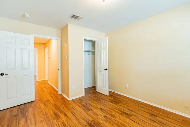 a view of a room with wooden floor and a bathroom