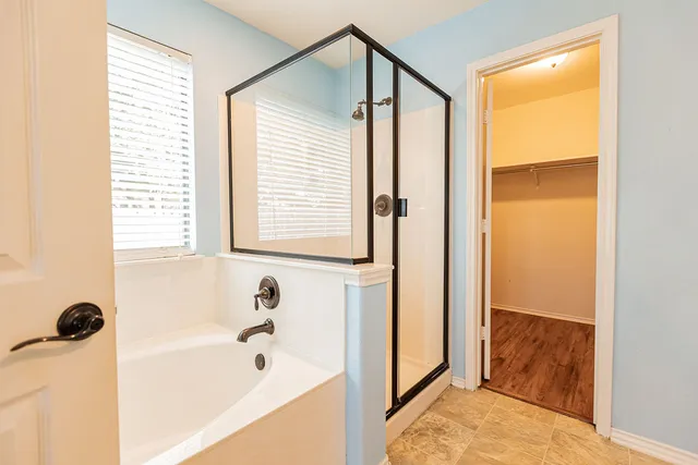 a bathroom with a bathtub and a shower