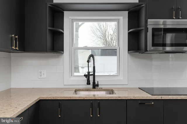 a kitchen with granite countertop a sink and a stove