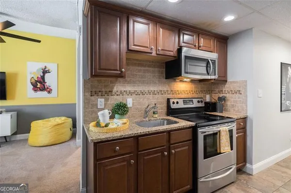 a kitchen with stainless steel appliances granite countertop a stove a sink and a microwave