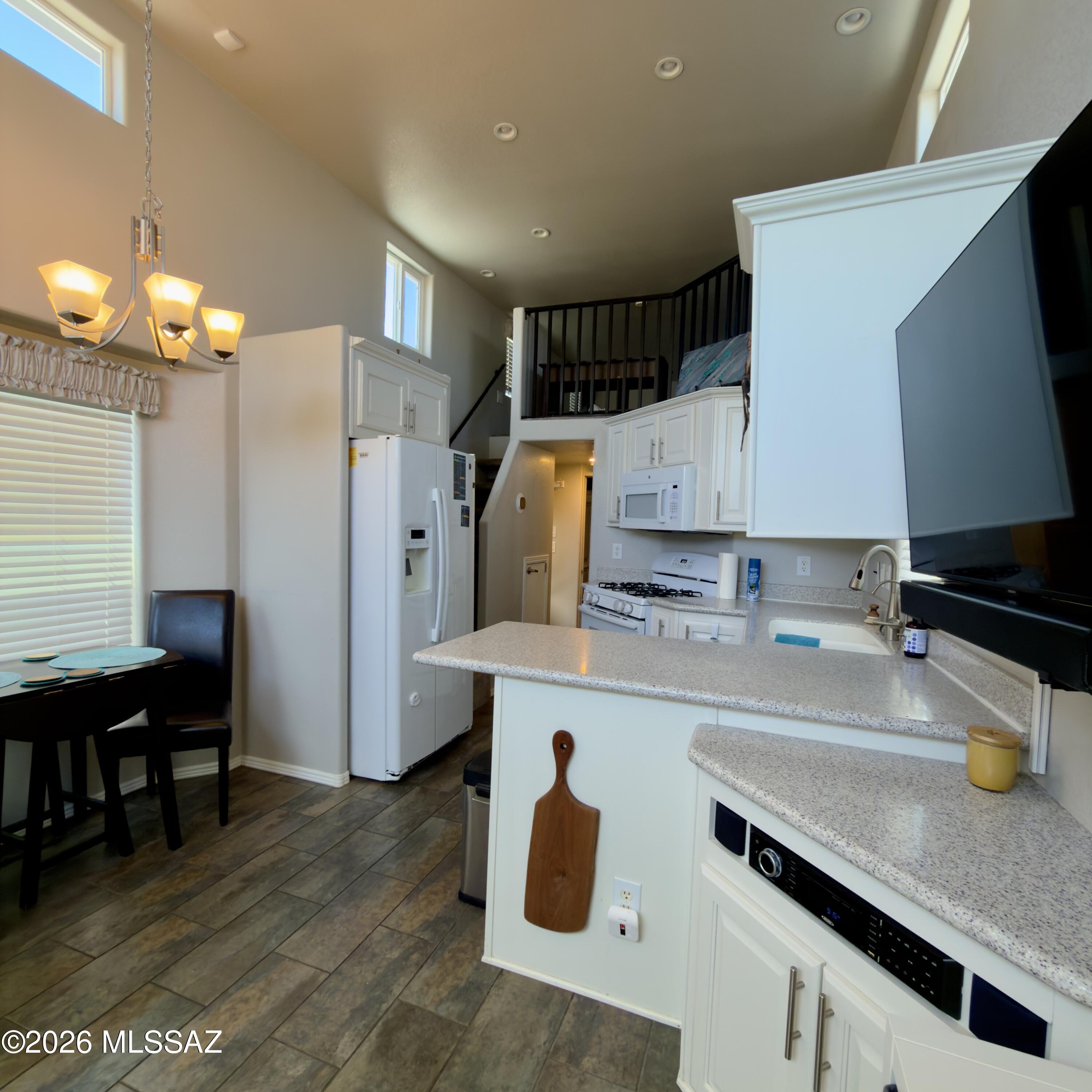 2843 19 Interstate 19 Frontage Road, Unit 116 Amado, AZ 85645 - Photo 7 of 32 a kitchen with a sink a refrigerator and chairs
