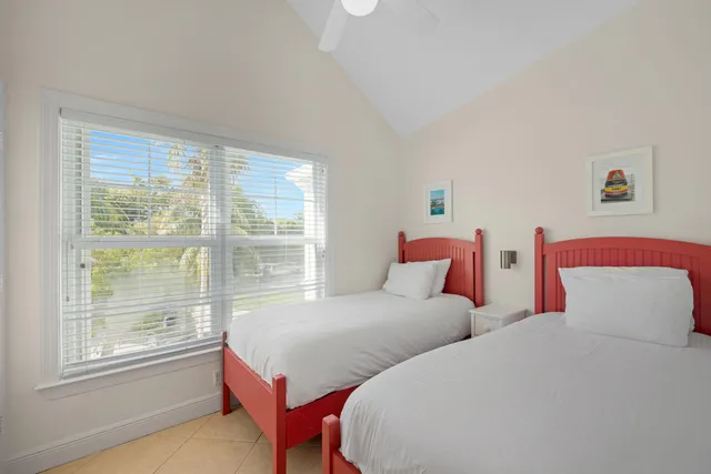 a bedroom with two beds and a large window