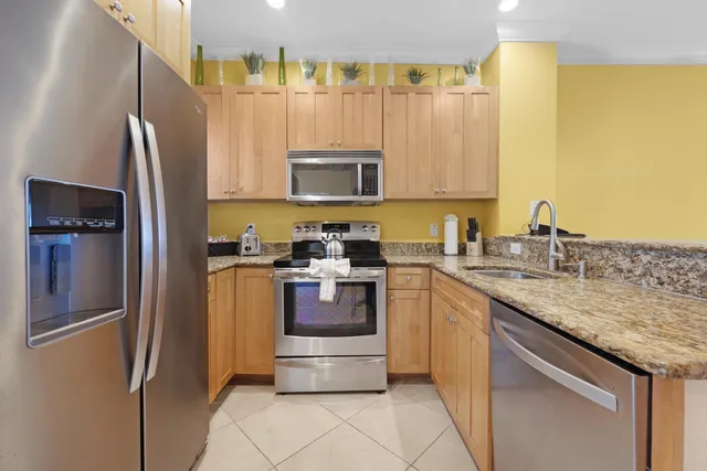 a kitchen with stainless steel appliances granite countertop a refrigerator sink and microwave