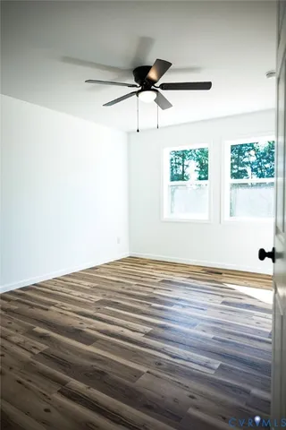 a view of empty room with window and wooden floor