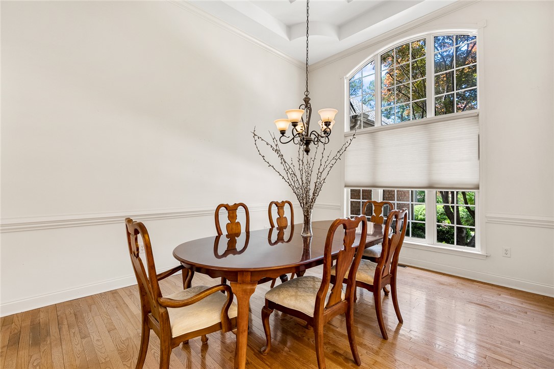 135 Sunset Bay Boulevard Seneca, SC 29672 - Photo 8 of 50 A refined dining space features hardwood floors, a tray ceiling, and a prominent arched window.