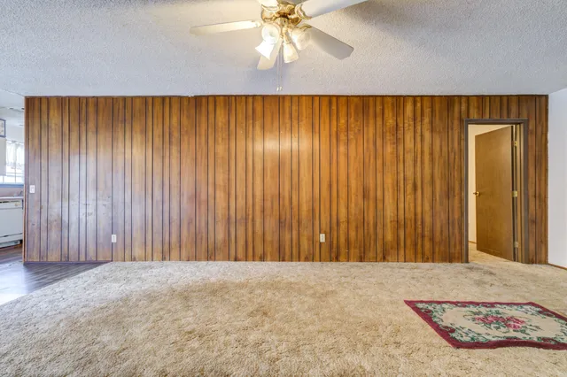 an empty room with closet and a chandelier fan