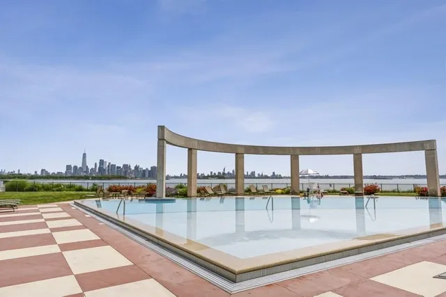 a view of swimming pool with outdoor seating and city view