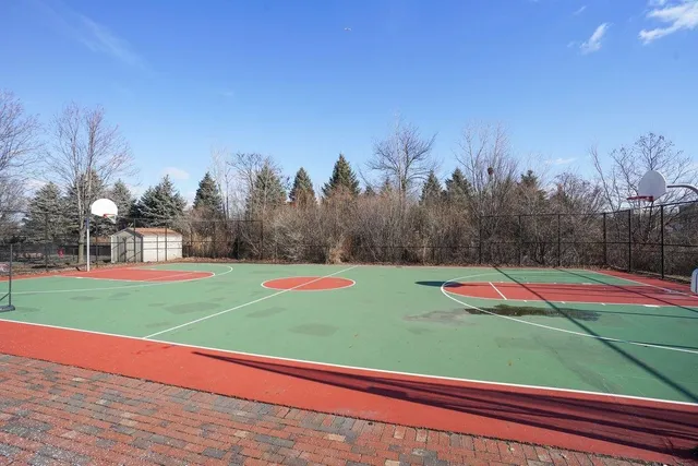 a view of a tennis ground with large trees
