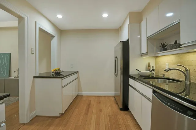 a kitchen with stainless steel appliances a sink stove and cabinets