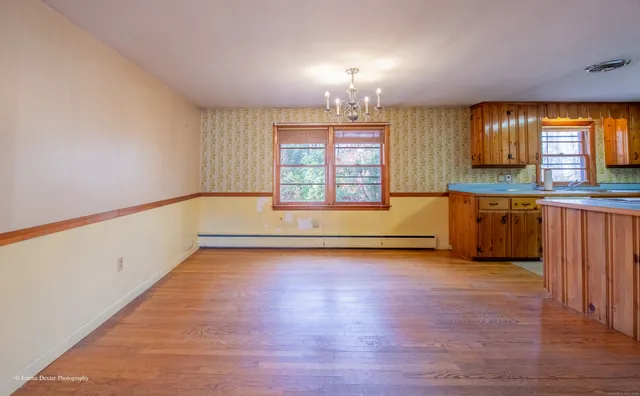 a view of a kitchen with wooden floor and a window