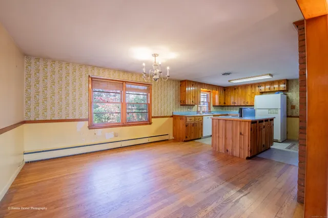an empty room with wooden floor and fireplace