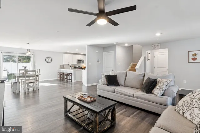 a living room with furniture and view of kitchen