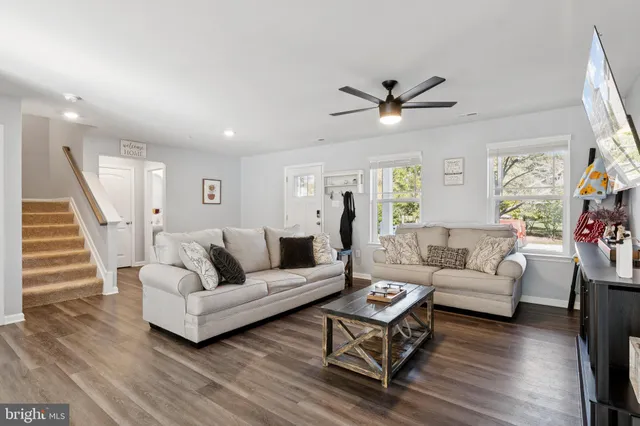a living room with furniture and a wooden floor