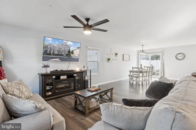 a living room with furniture a flat screen tv and a window